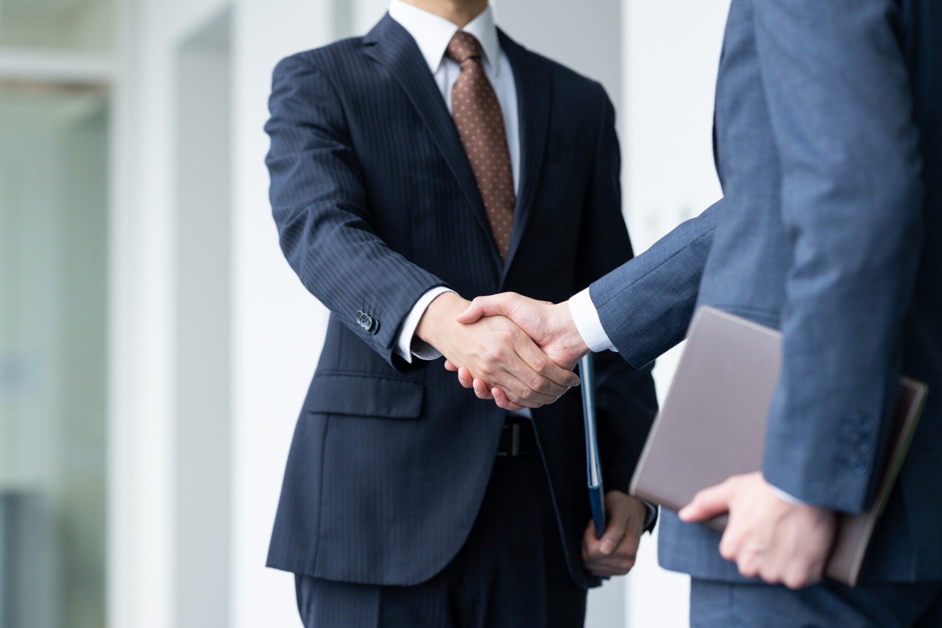 People in suits shaking hands.